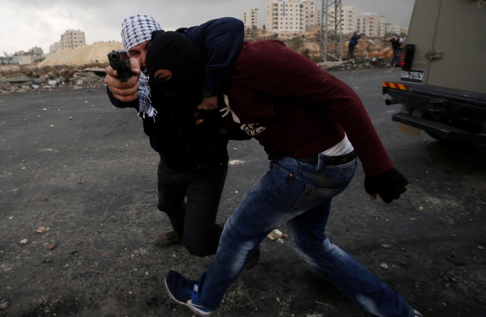 Un miembro de seguridad israelí encubierto detiene a un manifestante palestino durante una protesta contra la decisión del presidente estadounidense Donald Trump de reconocer a Jerusalén como la capital de Israel, cerca del asentamiento judío Bet El en Cisjordania.