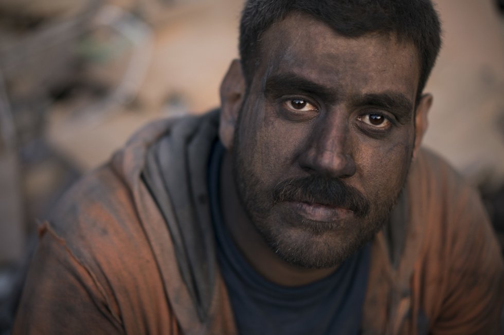 Ahmed Maha posa con la cara llena de suciedad tras un día de trabajo en tareas de desescombro en una tienda de la Ciudad Viejad e Mosul.