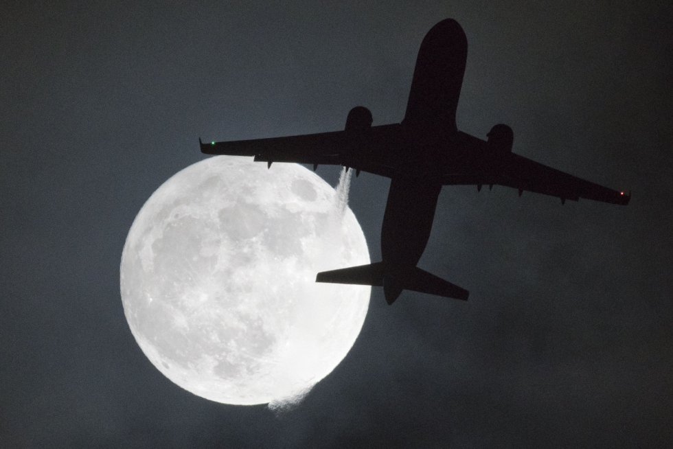 Un avión vuela cerca de la luna en el aeropuerto londinense de Heathrow, el 1 de enero de 2018.