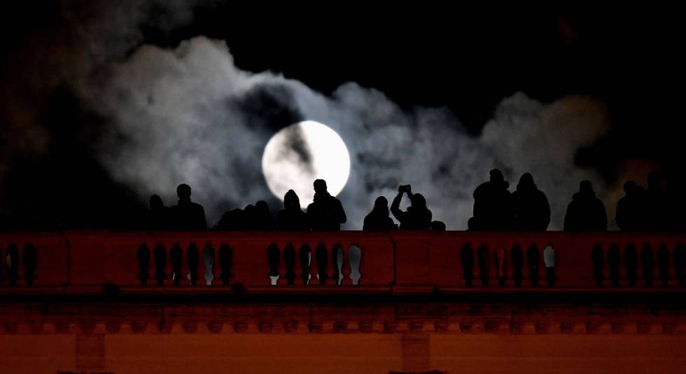 Un grupo de personas hacen fotos a la superluna en la ciudad italiana de Roma, el 1 de enero de 2018.
