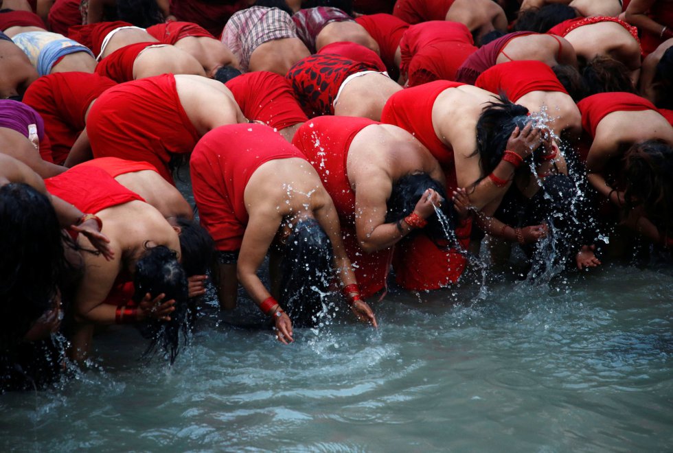 Los devotos toman un baño sagrado en el río Bagmati en el templo Pashupatinath durante el festival 'Swasthani Brata Katha' en Katmandú, (Nepal).