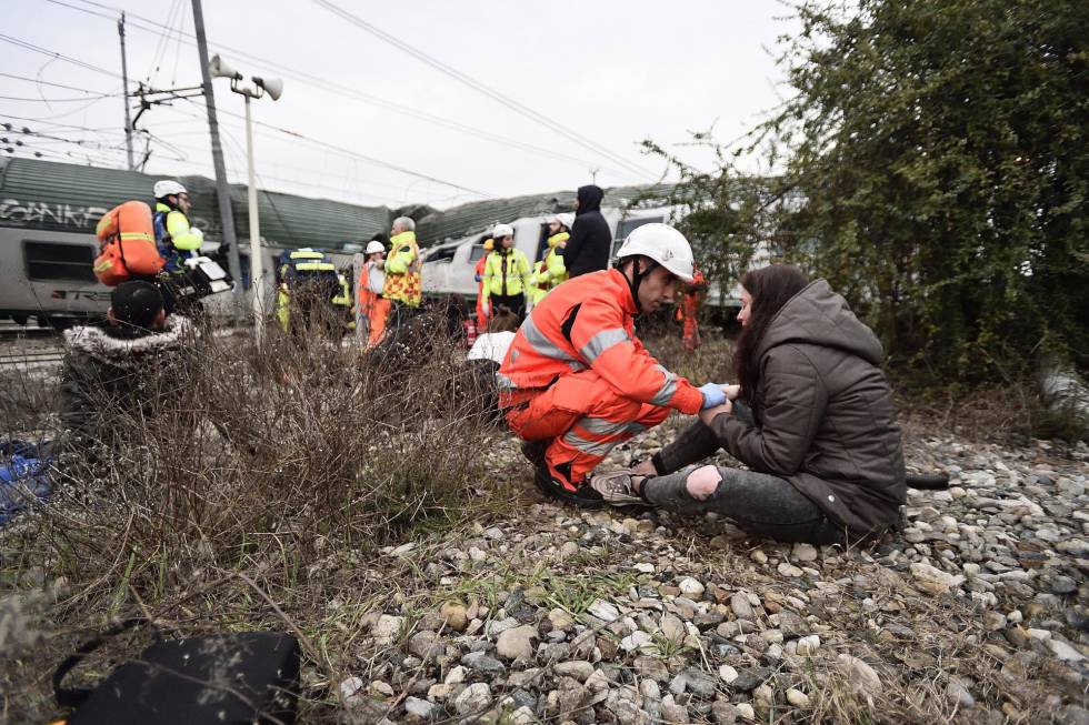 Un miembro de los servicios de emergencia asiste a una pasajera después de que un tren descarrilara cerca de Milán (Italia), 25 de enero de 2018.