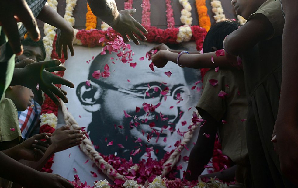 Alumnos de un colegio llenan de flores un retrato de Mahatama Gandhi durante los actos por el 70 aniversario de su asesinato, en Chennai (India).