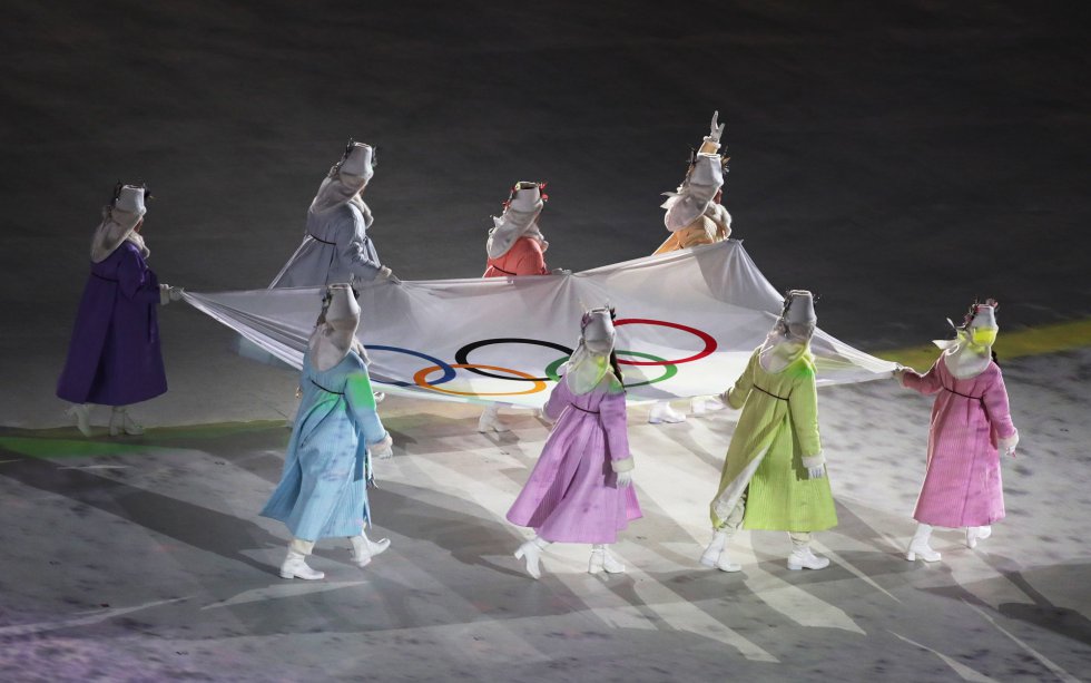 Voluntarias portan la bandera olímpica en el estadio de Pyeongchang durante la ceremonia de inauguración de los Juegos Olímpicos de Invierno 2018, el 9 de febrero de 2018. 