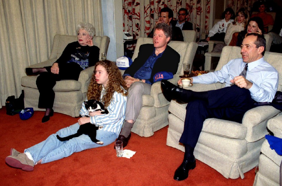 Bill Clinton (centro) mira la final de la Super Bowl del 31 de enero de 1993. Su hija, Chelsea, se sienta delante de su padre mientras abraza a su gato Socks.