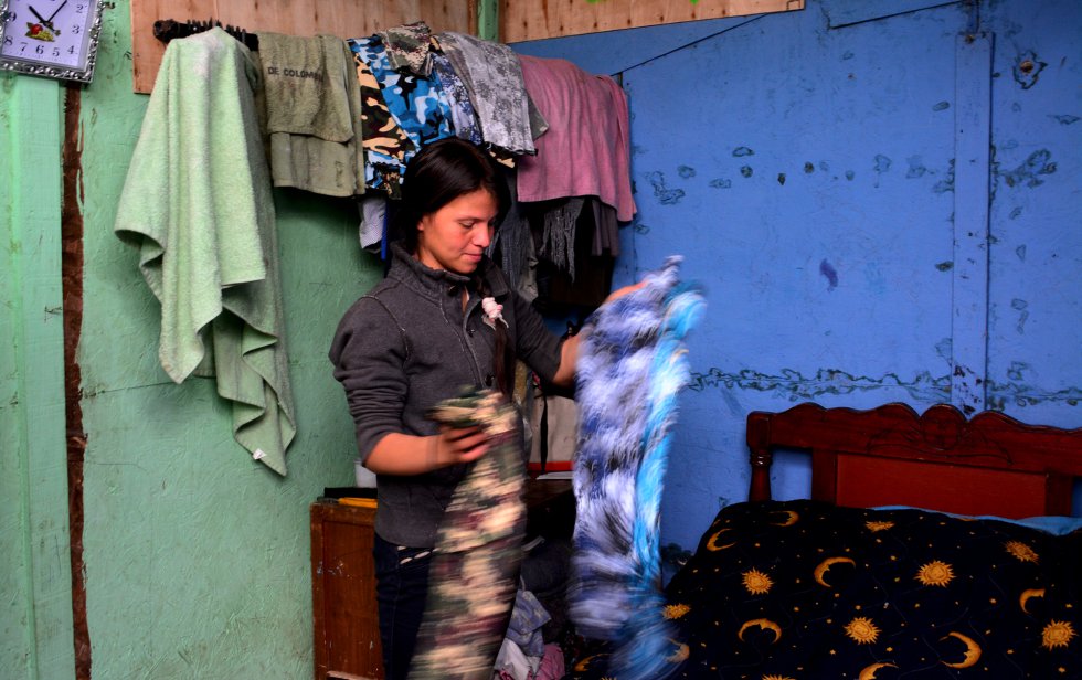 Jessica hizo crecer su negocio con un microcrédito. Otro más tarde le permitió diversificar para participar en el negocio de confección de ropa de su suegra. En su dormitorio, muestra algunas de las prendas que hacen. rn