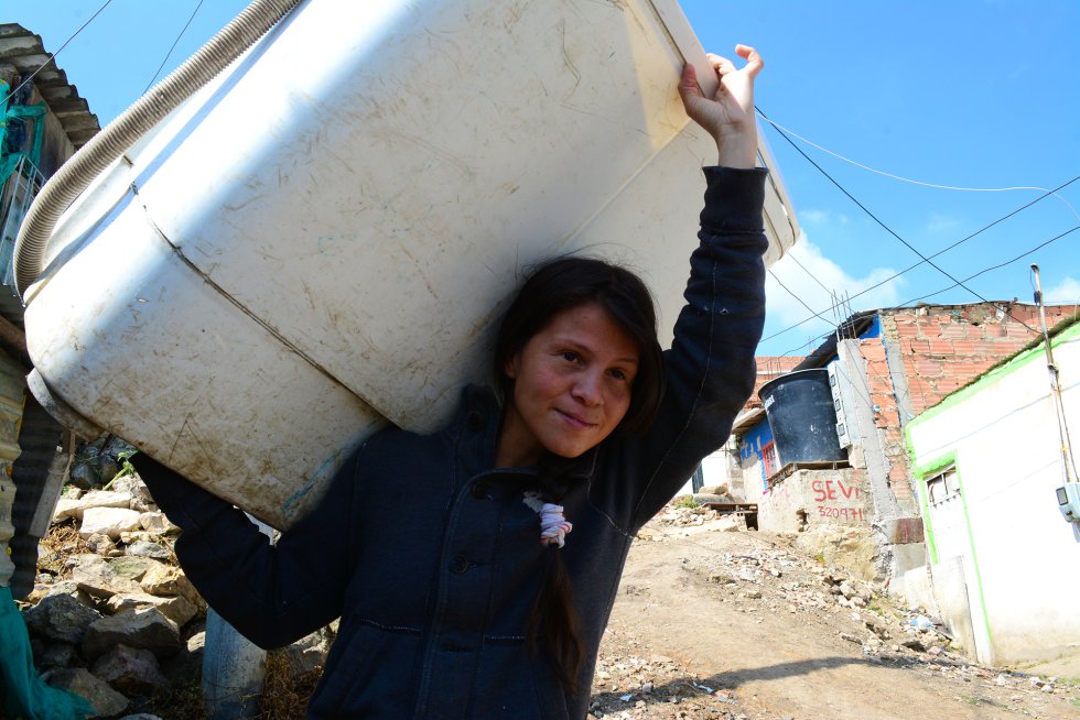 Jessica carga una lavadora para llevarla a casa de un vecino. Su espalda se resintió de este trabajo, así que ya no las alquila por horas, sino por días, lo que le ahorra viajes.rn