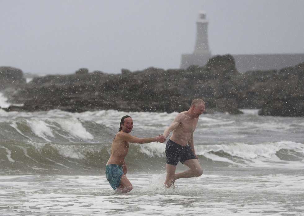 Dos bañistas salen del agua de la playa de Tynemouth (Inglaterra), el 27 de febrero.