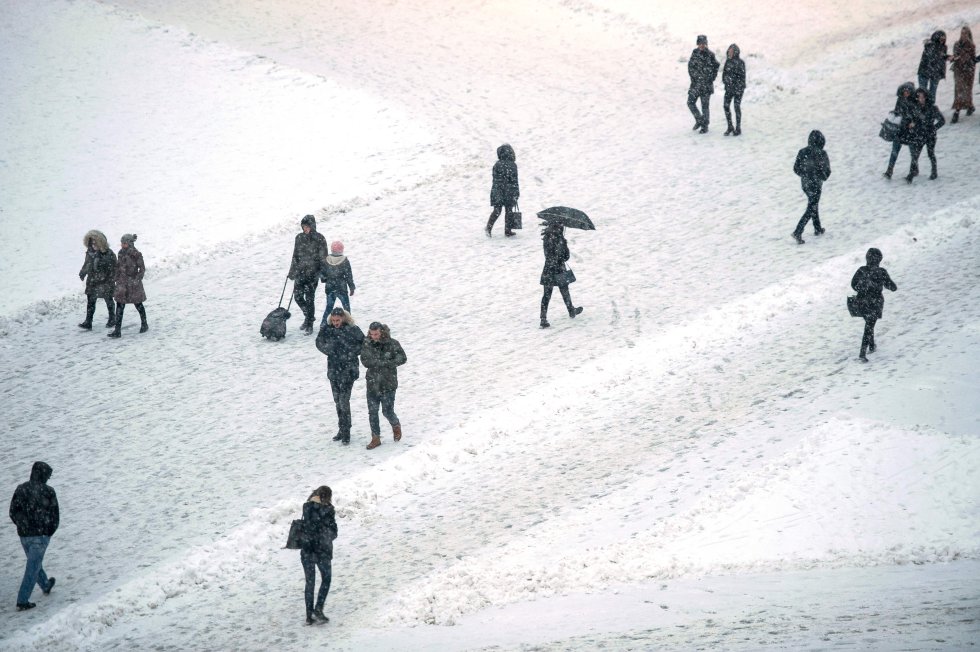 Viandantes caminan por una calle cubierta de nieve en Pristina (Kosovo), el 26 de febrero.