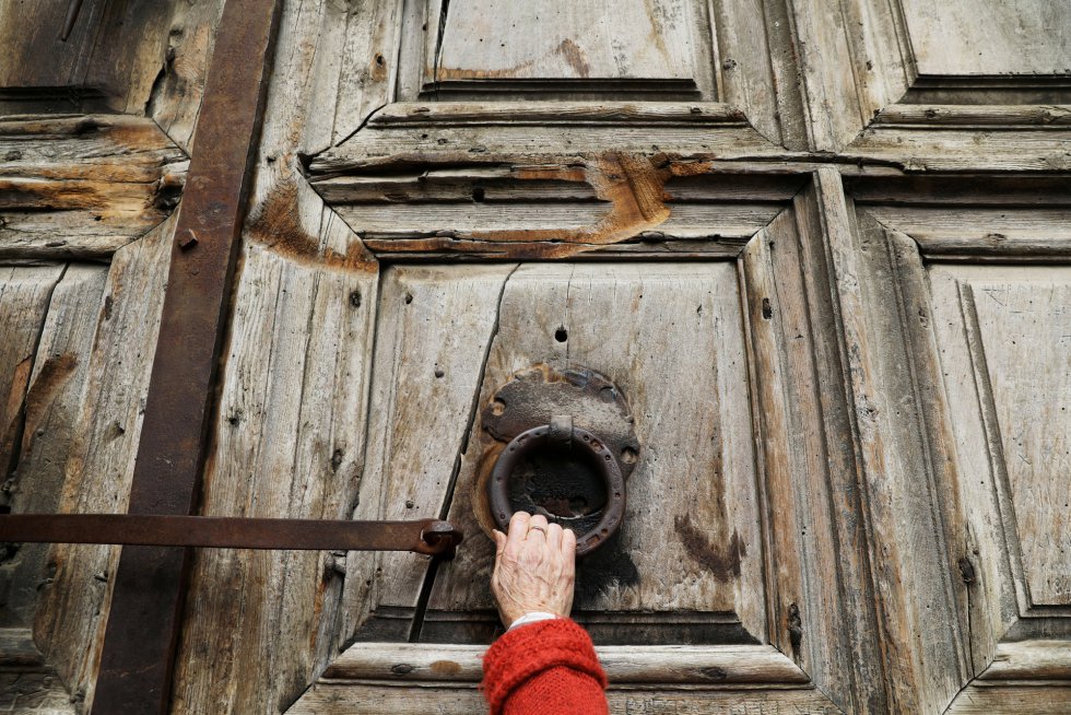 Una creyente toca las puertas cerradas de la Iglesia del Santo Sepulcro en la Ciudad Vieja de Jerusalén.