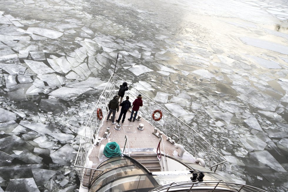 Pasajeros en la cubierta de un barco turístico que rompe el río congelado Moskva en Moscú (Rusia).