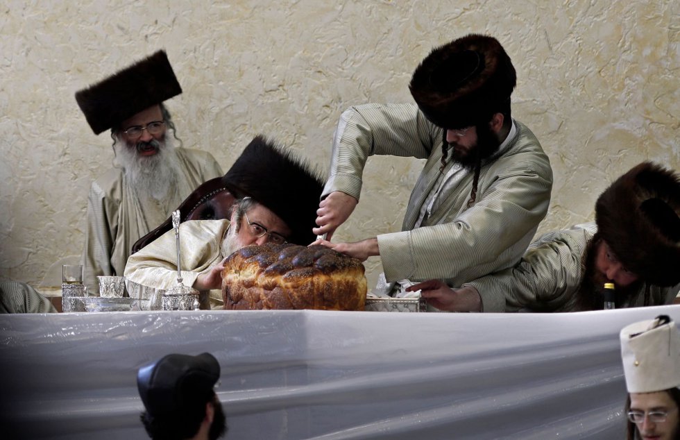 Rabinos judíos cortan un pan tradicional en una escuela religiosa del barrio ultraortodoxo de Jerusalén, Mea Sharim, el 2 de marzo.
