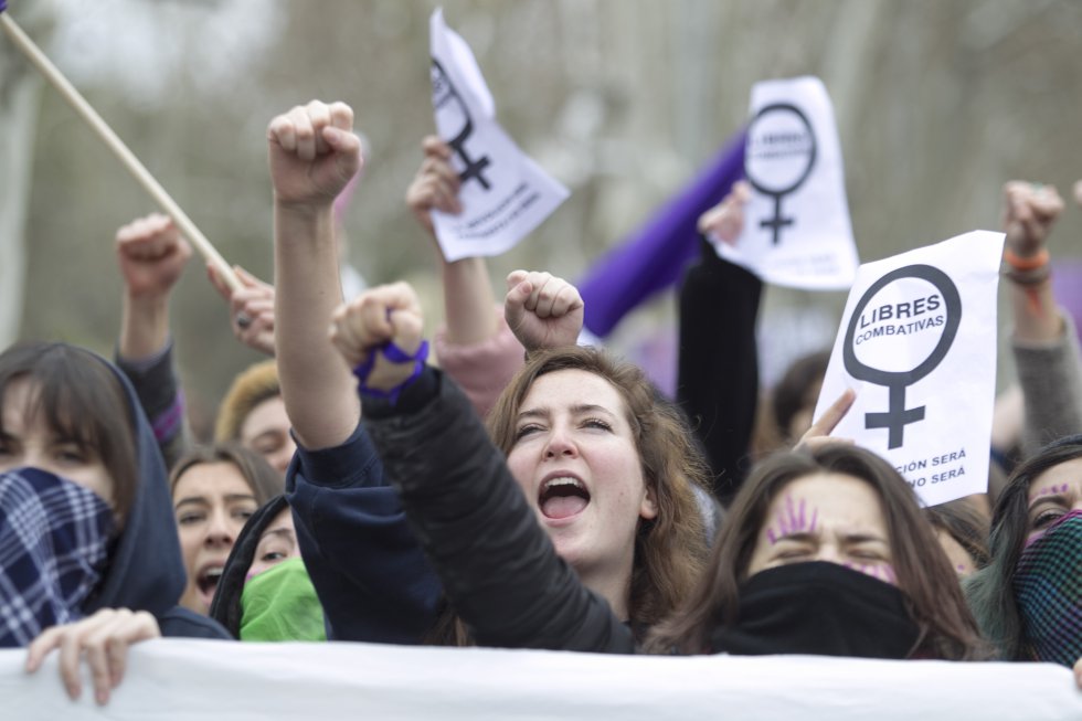 Varias jóvenes alzan el brazo en señal de protesta durante la manifestación en la Ciudad Universitaria de Madrid.