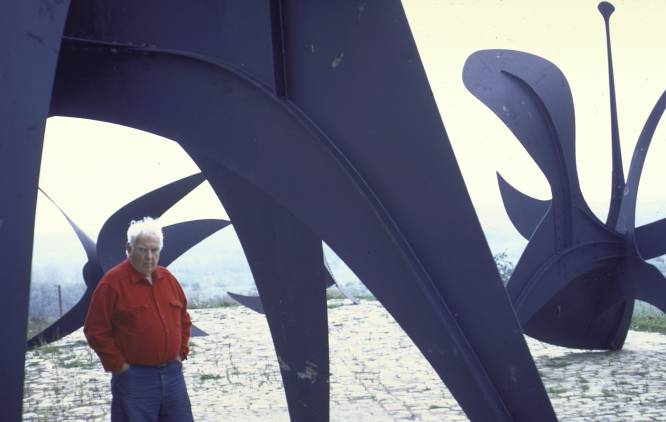  De que tesouro falamos. A Autoridade portuária de Nova York encomendou em 1969 uma grande escultura ao norte-americano Alexander Calder, conhecido sobretudo por seus móbiles de peças metálicas. As três placas de aço inoxidável pintadas de vermelho e unidas em uma forma que lembrava uma hélice foram colocadas na praça diante do World Trade Center, ainda em construção quando feito o pedido. A obra media quase oito metros de altura. Como desapareceu e por que ninguém o encontrou. Durante os ataques terroristas de 11 de Setembro não só morreram quase 3.000 pessoas, mas entre as perdas materiais houve também a de uma centena de obras de arte. Esta é a mais conhecida, e a mais valiosa, mas havia também um tapete de Miró, por exemplo. Qual é seu valor. O total foi estimado em cerca de 100 milhões de dólares (341 milhões de reais), mas suspeitamos que poderia alcançar bem mais. Na foto, Alexander Calder ao lado de uma de suas esculturas.