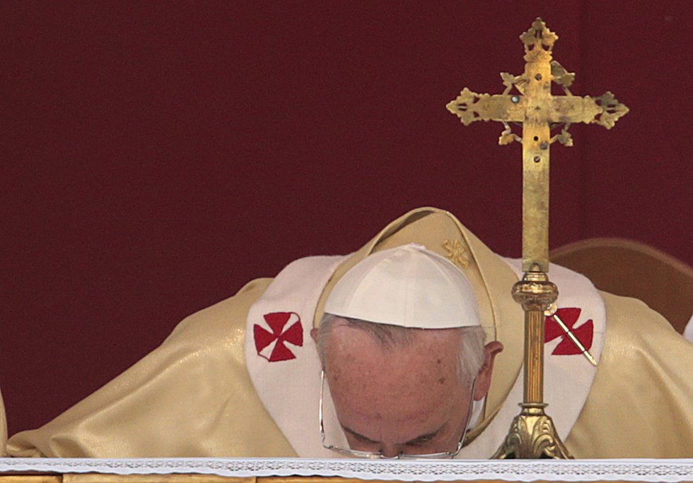 El papa Francisco besa el altar durante la celebración de una misa el día de Todos los Santos, en el cementerio Verano de Roma, el 1 de noviembre de 2013.