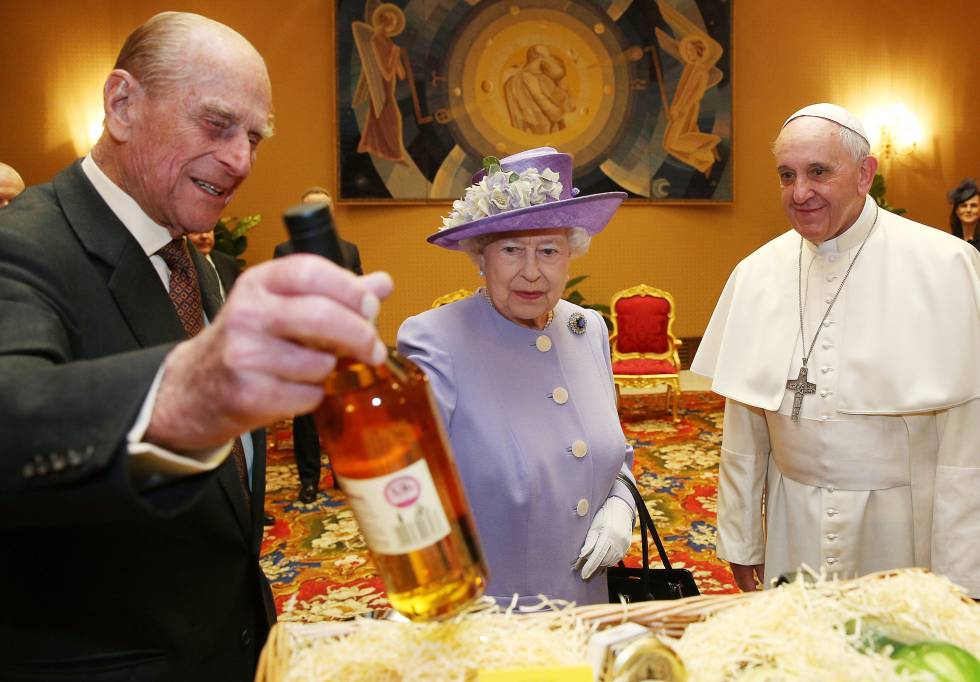 El príncipe Felipe, duque de Edimburgo, muestra una botella de vino a su mujer, la reina Isabel, cabeza de la Iglesia Anglicana, y al papa Francisco, en una audiencia en el Vaticano, el 3 de abril de 2014.