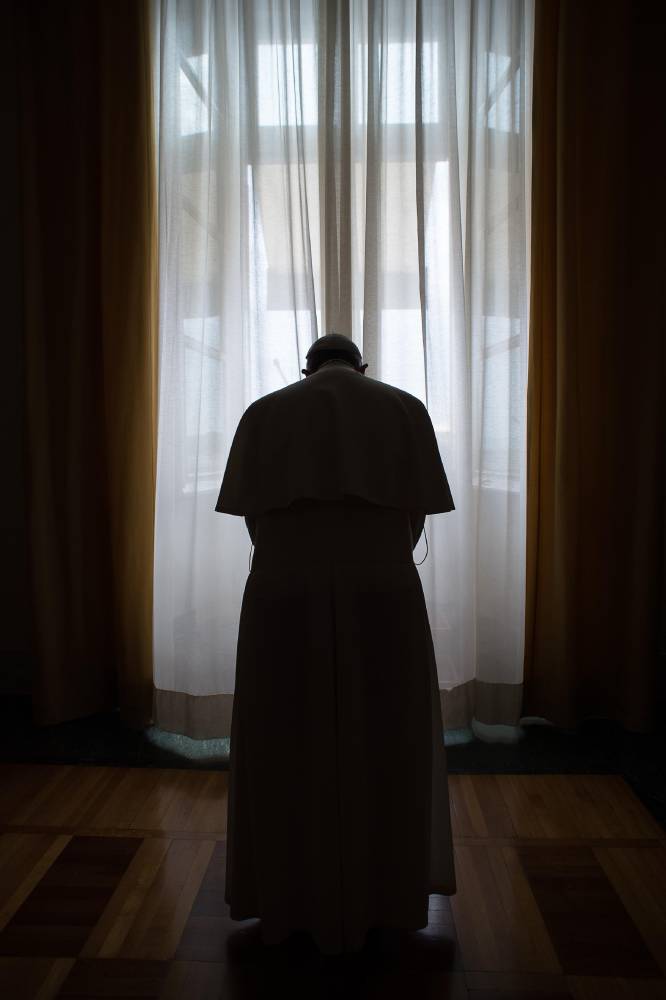 El papa Francisco reza a solas antes del ángelus desde el balcón de la basílica de San Pedro, el 26 de enero de 2015.