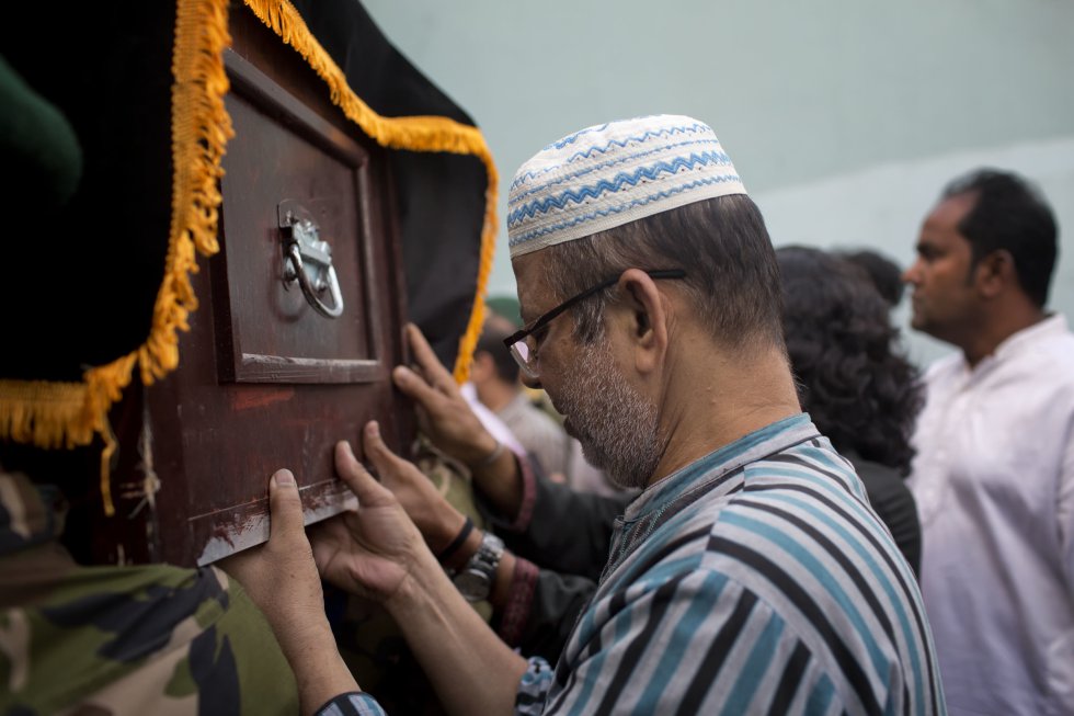 Un familiar sujeta el ataúd de una de las víctimas del accidente de avión en Nepal en Dhaka (Bangladés). 