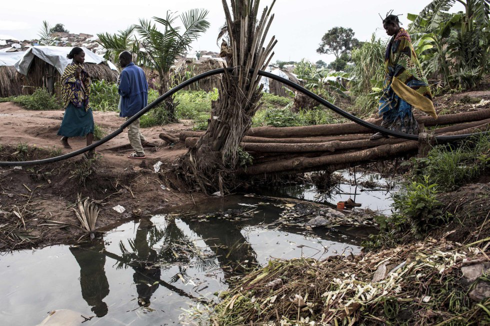  La malaria representa otro problema muy grave en Tanganica por la presencia del lago .  En la imagen, unos congoleños caminan en un campamento para personas internamente desplazadas el 20 de marzo de 2018 en Kalemie (República Democrática del Congo). 