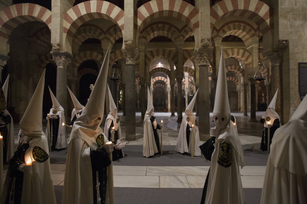 Penitentes de la hermandad de 'El Huerto' durante una procesión de Semana Santa en la mezquita de Córdoba.