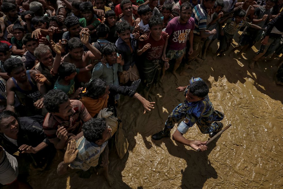 Um oficial de segurança tenta controlar os refugiados rohingyas que aguardam ajuda no Cox's Bazar (Bangladesh), em 21 de setembro de 2017.