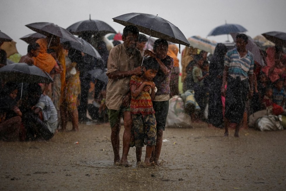 Refugiados rohingyas tentam se proteger das chuvas torrenciais enquanto estão retidos pela Guarda de Fronteiras de Bangladesh (BGB), depois de atravessar ilegalmente a fronteira, em Teknaf (Bangladesh), em 31 de agosto de 2017.