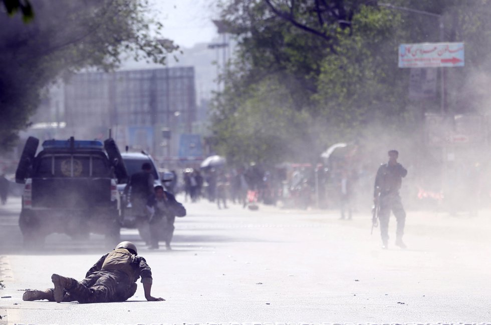Un miembro de seguridad permanece en el suelo tras el segundo ataque terrorista en la ciudad de Kabul (Afganistán).