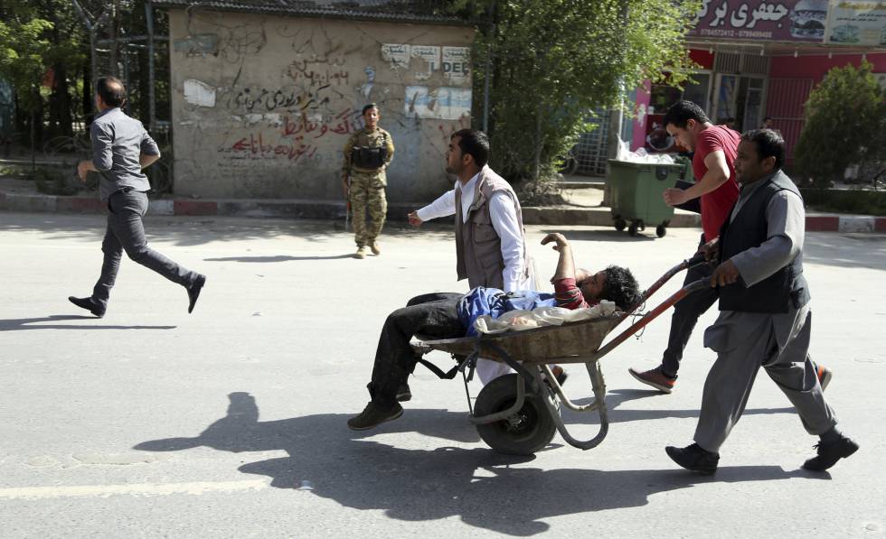 Varias personas transportan a un herido tras el segundo atentado terrorista en la ciudad de Kabul.