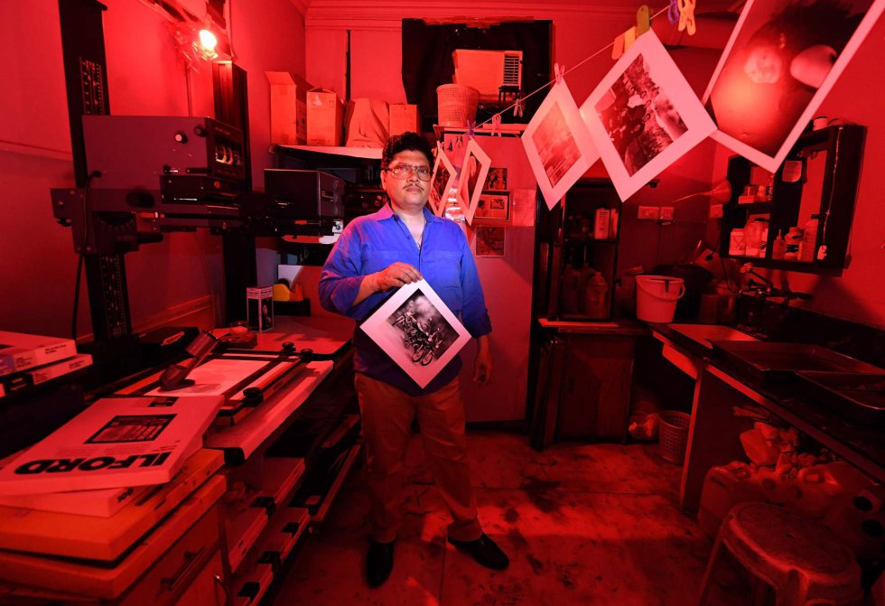 Vicky Luthra, un experto en revelado y positivado, posa con una fotografía en blanco y negro en el cuarto oscuro de sus estudios de impresión SV, en Nueva Delhi, el 19 de abril de 2018.