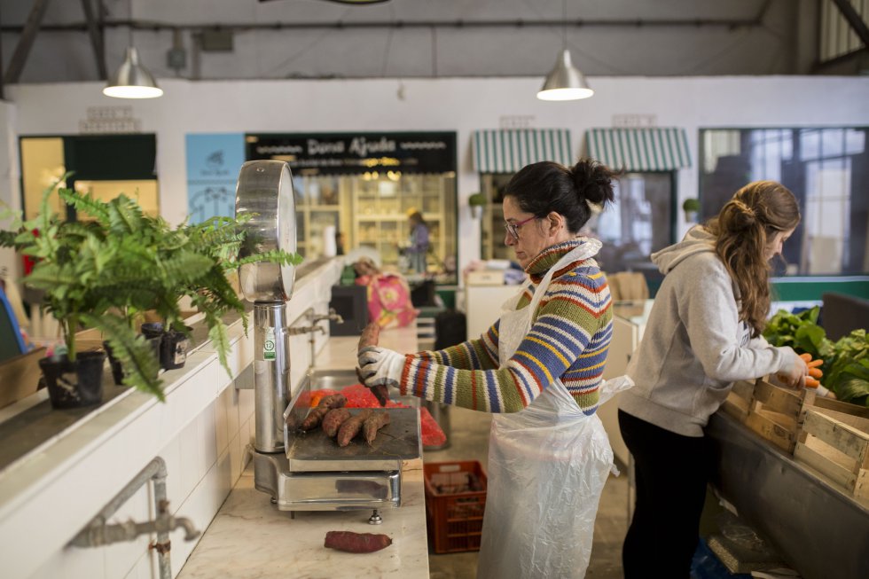 Una voluntaria pesa unos boniatos para que después distribuirlos en las cajas. La cooperativa logra comprar los vegetales a la mitad del precio de mercado y asegura que todo el dinero recaudado se invierte en el proyecto.