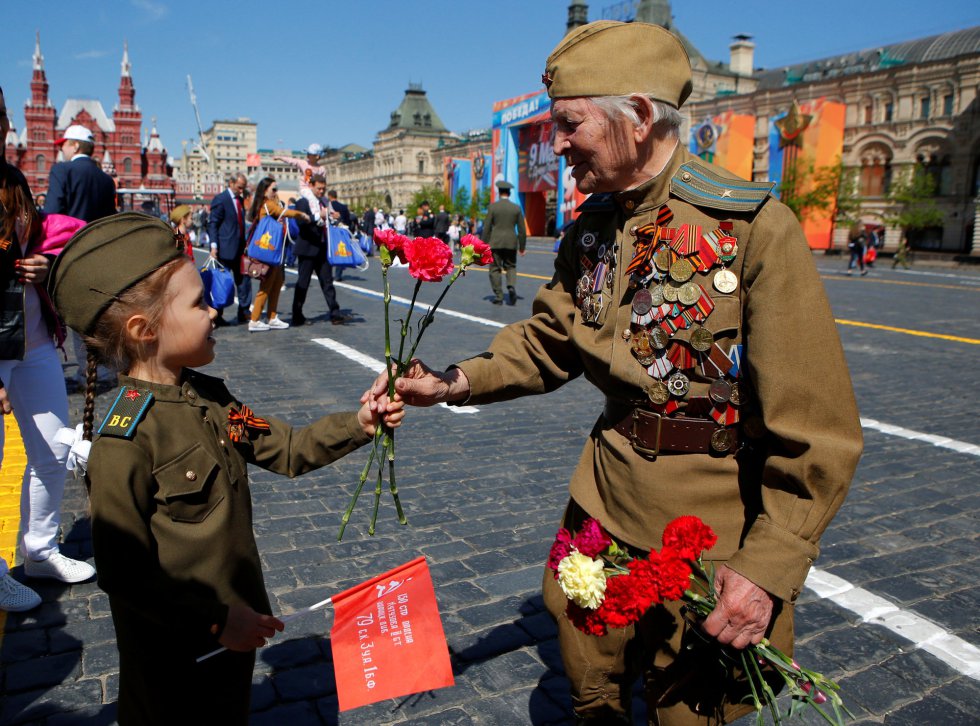 Una niÃ±a le entrega una rosa a un veterano de guerra durante la celebraciÃ³n del DÃ­a de la Victoria en Rusia.