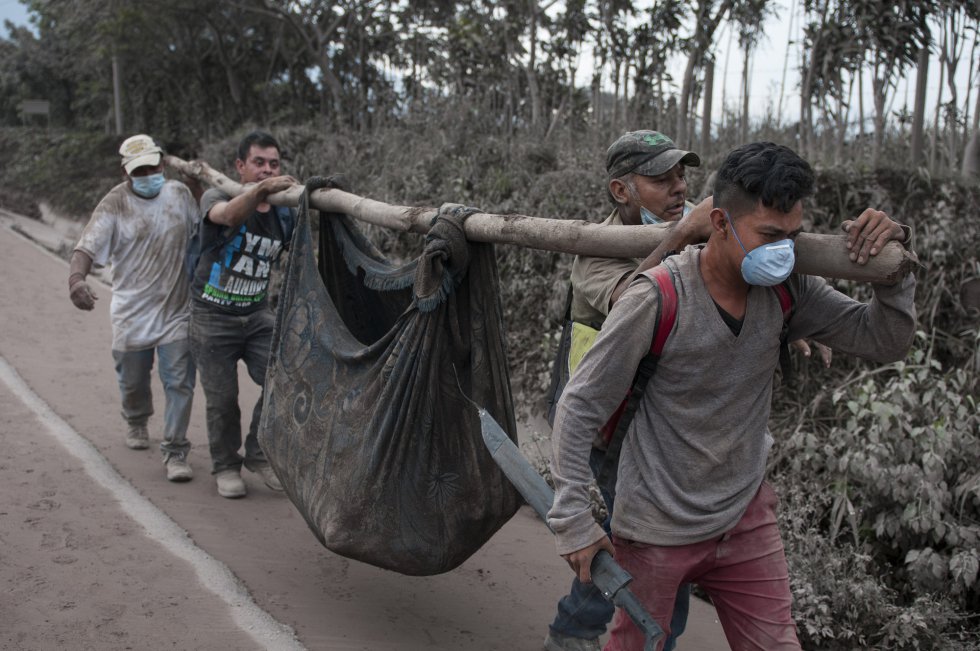 Vecinos transportan el cuerpo sin vida de una víctima de la erupción del volcán de Fuego en Escuintla, (Guatemala).