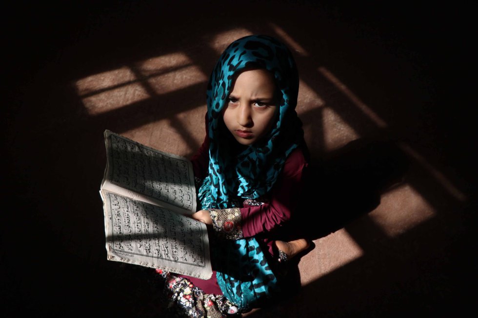 Una niña lee el Corán durante el mes del Ramadán en una mezquita de Herat (Afganistán).