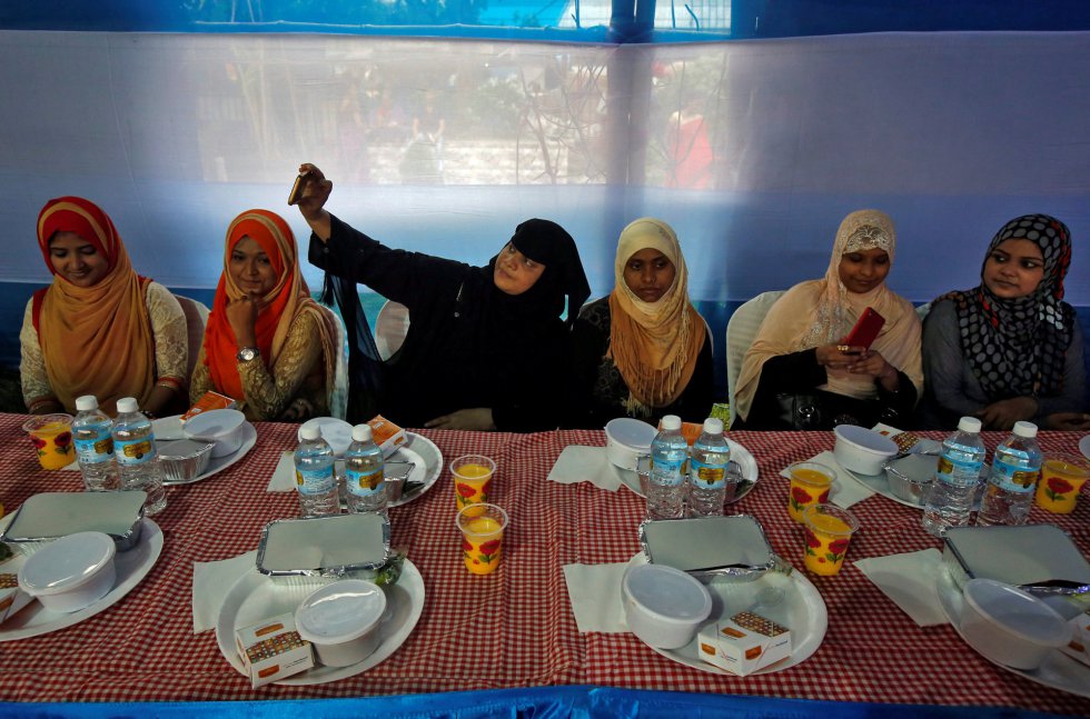 Una mujer se hace un selfi mientras ella y otras mujeres se preparan para tomar el Iftar y romper así el ayuno en Calcuta (India).