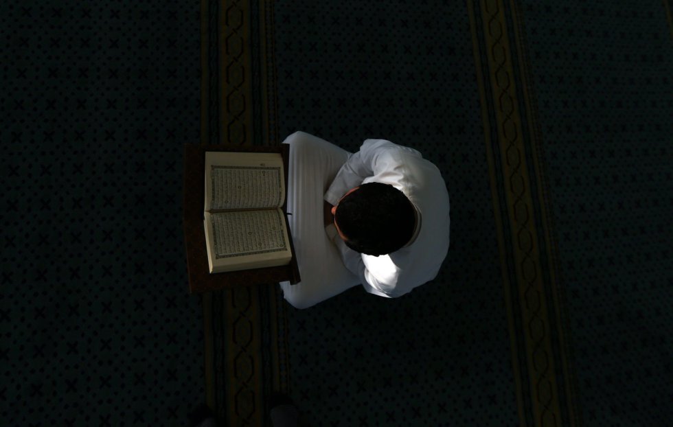 Un musulmán lee el libro del Corán en la mezquita Bani Hashim antes del atardecer durante el sagrado mes del Ramadán, en Abu Dabi (Emiratos Árabes Unidos).
