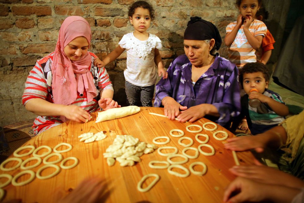 Mujeres egipcias preparan Kahk, galletas de mantequilla elaboradas en un horno tradicional sin puerta en la villa de Dalgamon (Egipto). Los egipcios musulmanes se preparan para celebrar el Eid al-Fitr, un festival religioso que marca el fin del mes del RamadÃ¡n. 