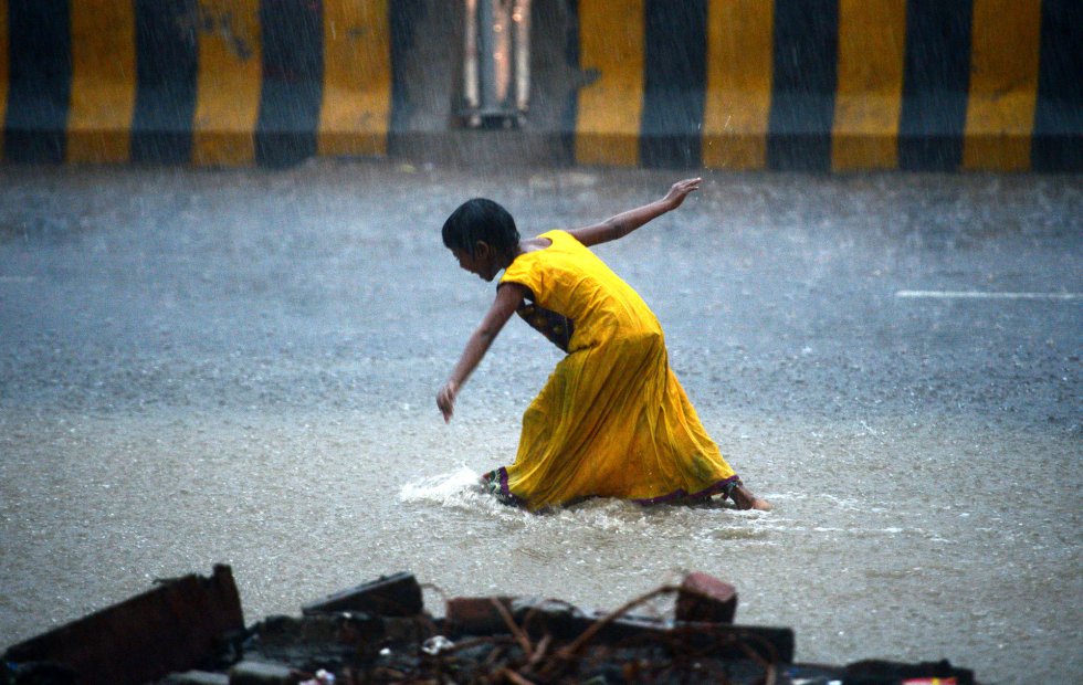 Una niña india camina por una carretera inundada durante unas fuertes tormentas en Allahabad (India).  