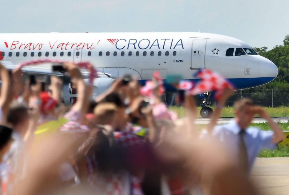 Un grupo de aficionados vitorea tras el aterrizaje del Airbus 319 con la selecciÃ³n croata de fÃºtbol a bordo en el aeropuerto de Zagreb.
