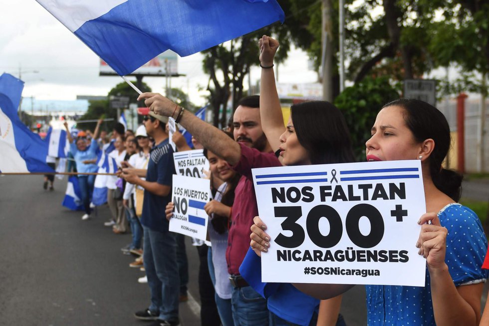 Manifestantes contra el gobierno sujetan pancartas contra la violencia en el país mientras hacen una cadena humana en Managua (Nicaragua), el 4 de julio de 2018.