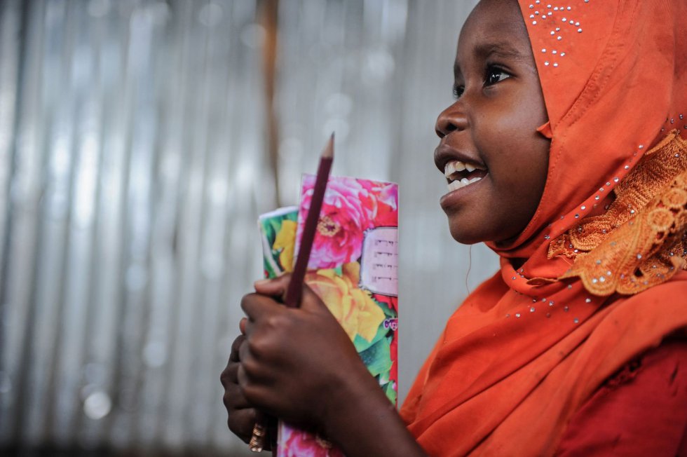 Una niña somalí llega a un colegio improvisadoen el campo de desplazados de Badbado en Mogadiscio (Somalia)  para aprender el alfabeto y los números.