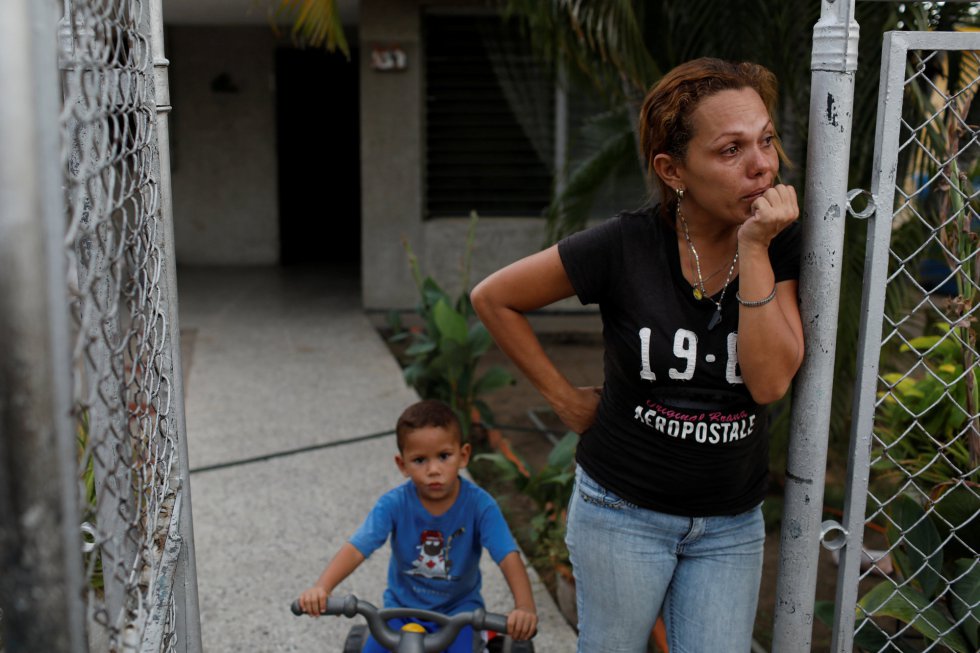 Cindy Morales se encuentra en la puerta del patio trasero de su casa durante un apagón, cada vez más frecuentes, que tienen que soportar cada vez más a menudo.