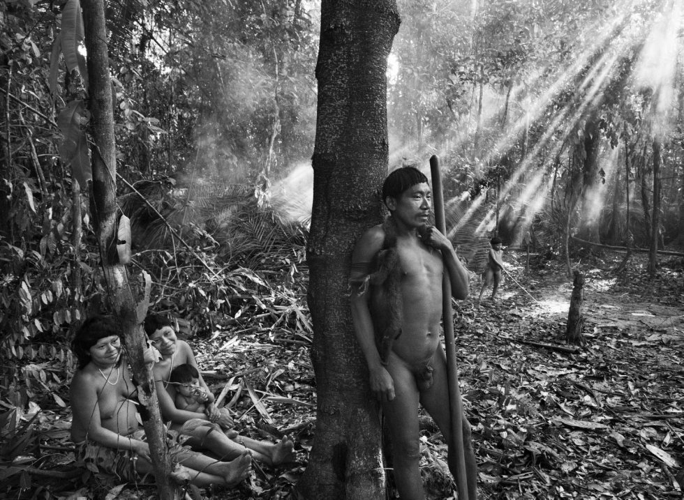 De pie, Manisvo con un palo de madera. Sentadas, Manisvo y Kulutxia, sentada con la pequeÃ±a Maya Koluvo en brazos.