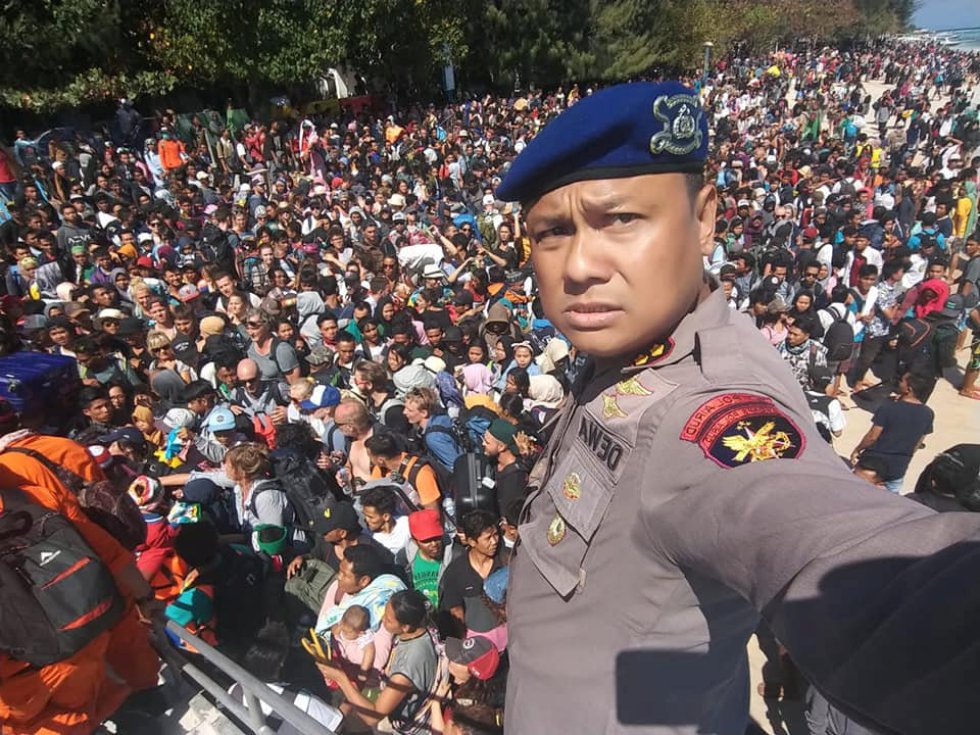 El Jefe de policía de Lombok, Dewa Wijaya, se toma una fotografía frente a los cientos de turistas tratando de abandonar las islas Gili tras el terremoto, el 6 de agosto de 2018. 