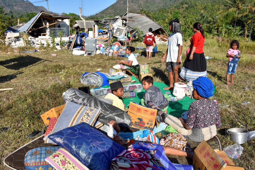 Residentes descansan frente a sus casas junto a sus pertenencias en Pemenang, Lombok, el 6 de agosto de 2018. 