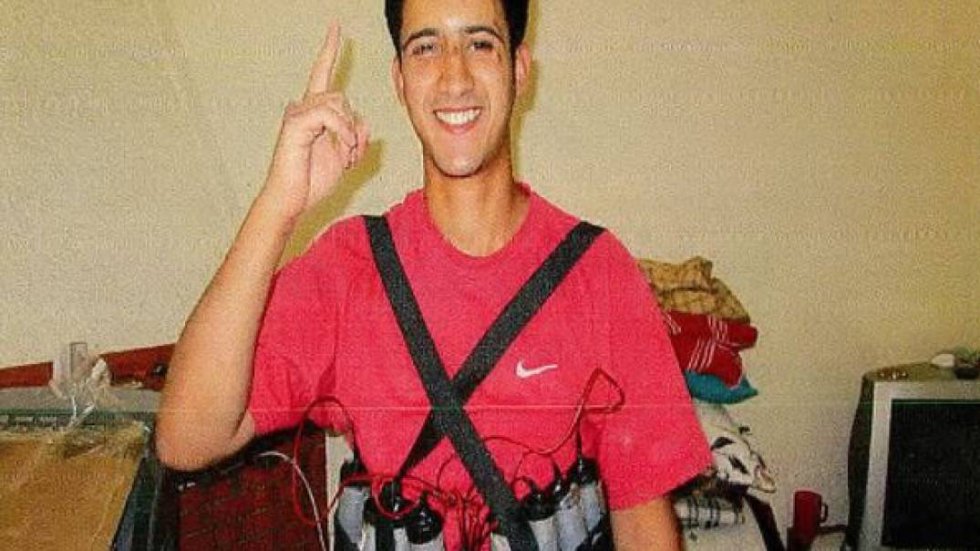 Youssef Aalla posa con un chaleco de explosivos. Sonríe mirando a cámara mientras levanta el dedo índice, una declaración de fe en la religión islámica. Su cadáver fue hallado en la vivienda de Alcanar (Tarragona) después de la explosión.