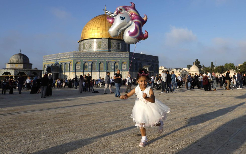 Una niña corre con un globo de helio frente a la Cúpula de la Roca de la ciudad de Jerusalén, el 21 de agosto de 2018.