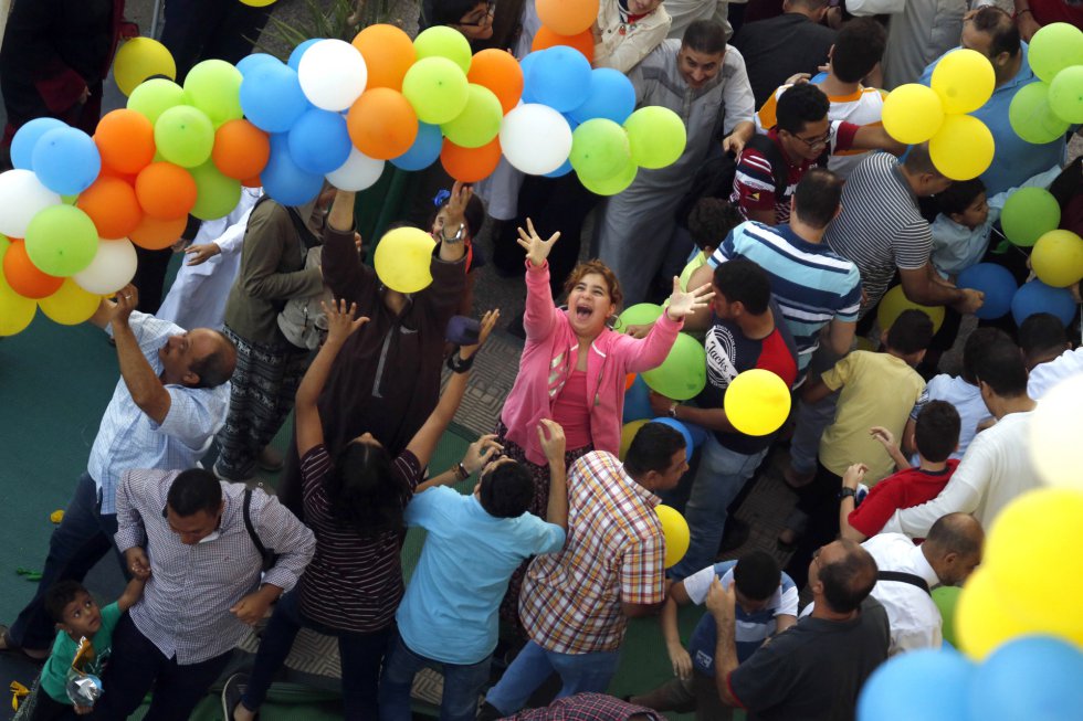 Varias personas tratan de coger globos frente a la mezquita al-Seddik de El Cairo, Egipto, el 21 de agosto de 2018.