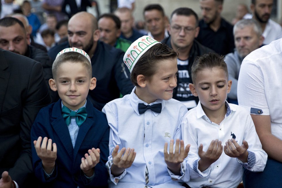 Tres niños participan en los rezos de Eid al-Adha en la mezquita Sultan Mehmet Fatih de Pristina, Kosovo, el 21 de agosto de 2018.