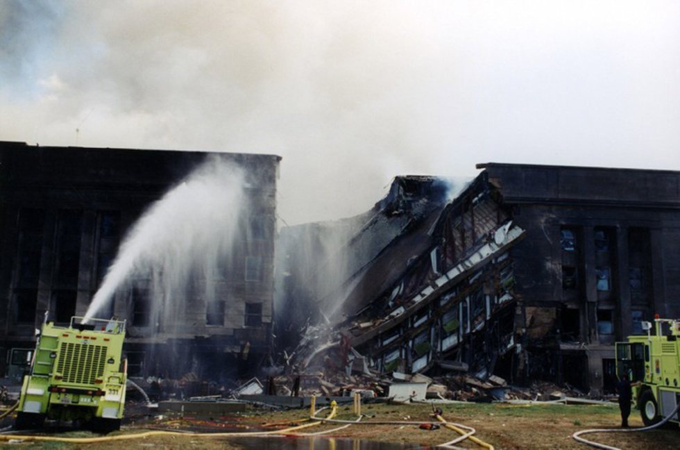 I vigili del fuoco cercano di estinguere l'incendio che è iniziato dopo che il volo 77 della American Airlines ha colpito le strutture del Pentagono.