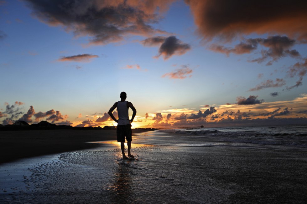 Andrew Lingle camina por la playa al amanecer mientras el huracán Florence se acerca a la costa este en Atlantic Beach, en el condado de Carteret en el estado de Carolina del Norte.